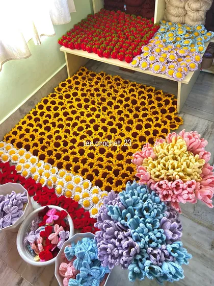 An overhead view of a massive 700-piece keychain order. This assortment includes colorful bow keychains, sunflowers, daisies, and strawberries, ready for a reseller.
