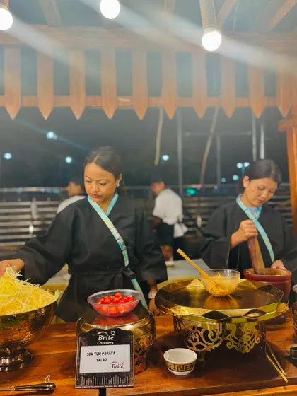 The chefs at the wooden Thai counter, demonstrating the art of making this classic salad for guests.