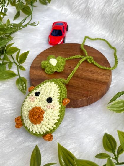 The avocado car hanging displayed on a wooden disc.