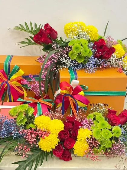 A colorful wedding gift created for a 'Fiesta' themed brunch. This hamper includes luxury gifts from Louis Vuitton, surrounded by a vibrant explosion of fresh flowers.
