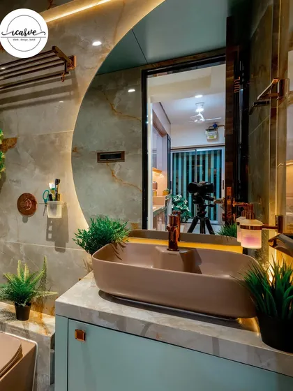 A close-up of the vanity area, showing the detail of the vessel sink, copper tap, and the reflection of the well-lit space in the large mirror.