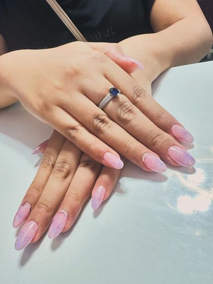 A dreamy set of nails with a soft pink and purple cloud-like effect and a touch of shimmer.
