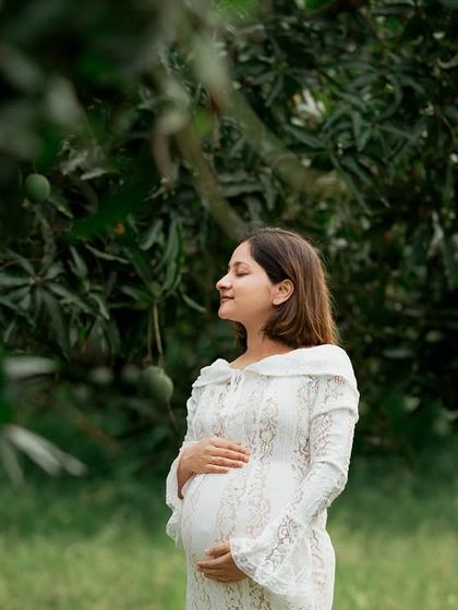 A peaceful outdoor maternity portrait. The mom-to-be is surrounded by lush greenery, creating a very natural and serene image.