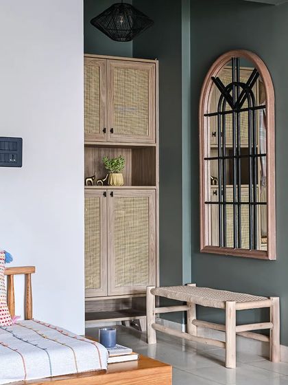 This foyer features a custom storage unit with cane-front cabinets and a coat niche to conceal the MCB box. An oversized custom French mirror gives the illusion of a larger space.