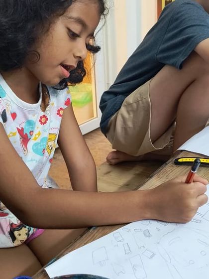 A young artist carefully sketches her design, fully absorbed in the creative process. We encourage focus and attention to detail in a relaxed and fun atmosphere.