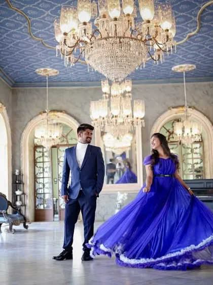 A full-view shot of the blue gown in a palace-like setting. The movement of the dress adds a dynamic element to this regal pre-wedding photo.