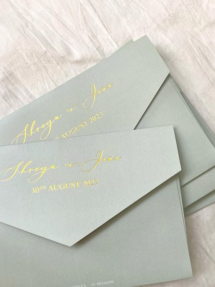 Elegant sage green envelopes with the couple's names and wedding date in a beautiful gold foil script. This is a perfect example of how a simple design can be incredibly sophisticated.