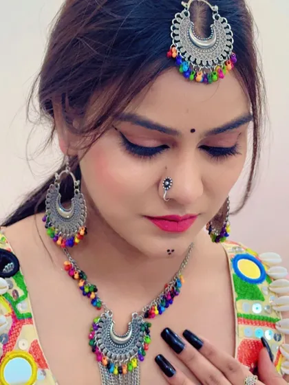 A model wearing the full multi-colored bead jewellery set, including the maang tikka, necklace, and earrings.