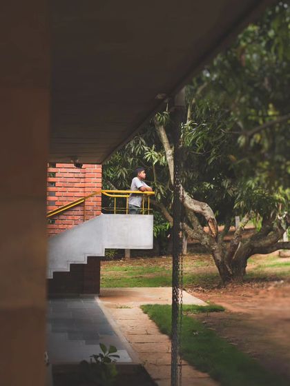 A view from the verandah towards the mango farm, a space designed for quiet reflection. The project's goal was to engage inhabitants with the bucolic landscape and the rhythms of farm life.