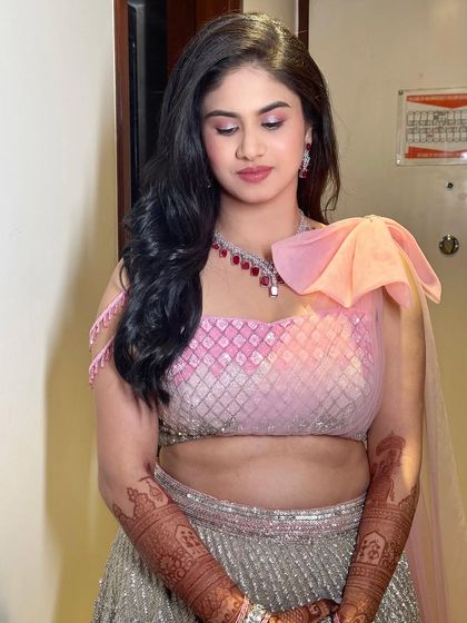 A close-up of the pink pastel makeup, featuring shimmery pink eyeshadow and a soft pink lip that complements her ruby necklace.