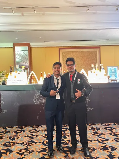 Posing with a guest in front of our stylish bar setup. It's all about creating a friendly and welcoming atmosphere for everyone.