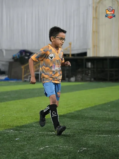 A young player running during a warm-up drill, building stamina and preparing his body for an intense training session.