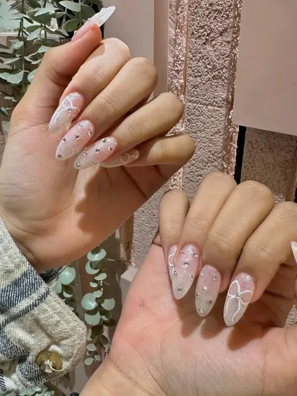 The stiletto shape adds a touch of drama to these otherwise sweet and delicate bow-adorned nails.