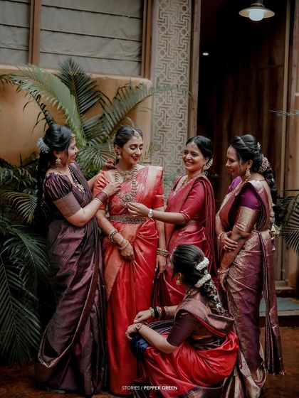 The bride, Bhagya, surrounded by her bridesmaids in matching sarees. This portrait captures the elegance and unity of the bridal party.