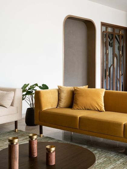 An ochre velvet sofa with clean lines and brass-capped legs serves as the anchor for this informal living space. We love using bold, warm colors to create inviting areas for the family to gather.