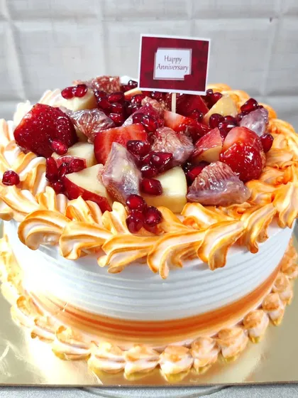 A beautiful fresh fruit anniversary cake. This one is loaded with strawberries, figs, apples, and pomegranate seeds.