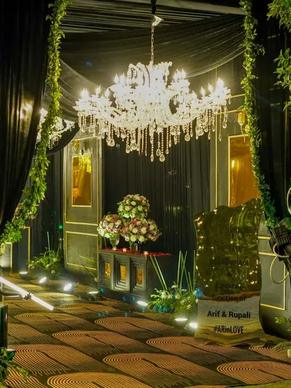 A grand, whimsical entrance for a cocktail affair. Crystal chandeliers, lush greenery, and dramatic black draping guide guests into a night of enchantment.