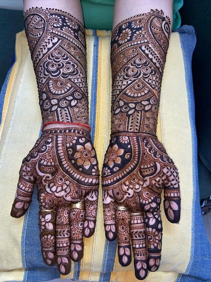 A beautiful full-hand design with a focus on floral mandalas and paisley patterns, creating a very rich and traditional look.