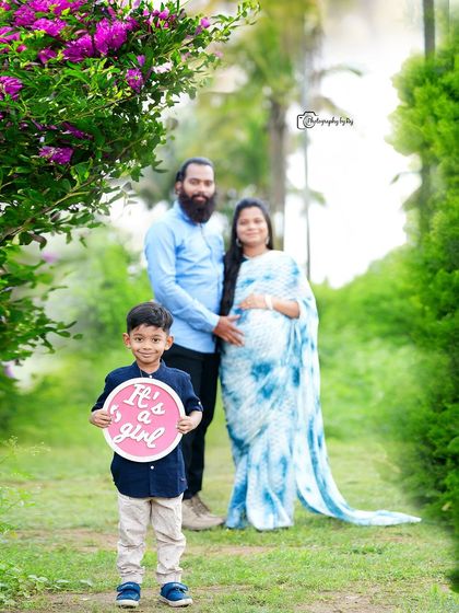 Another sweet gender reveal with the older sibling. Here, he holds a sign announcing "It's a girl!" while his parents look on lovingly.