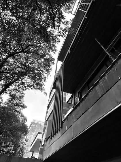 Another artistic, in-progress shot of a facade. The strong vertical lines of the metal fins contrast with the horizontal concrete slabs, showcasing the home's core architectural elements before they are clad and finished.