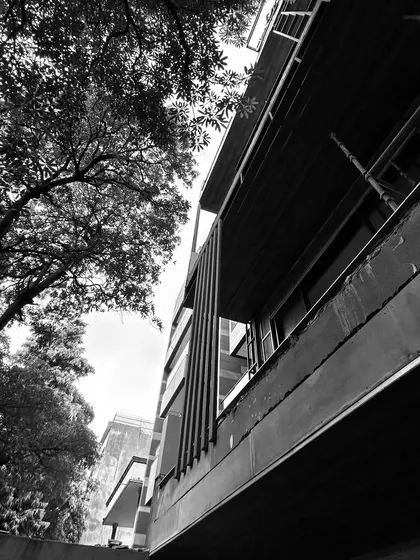 Another artistic, in-progress shot of a facade. The strong vertical lines of the metal fins contrast with the horizontal concrete slabs, showcasing the home's core architectural elements before they are clad and finished.