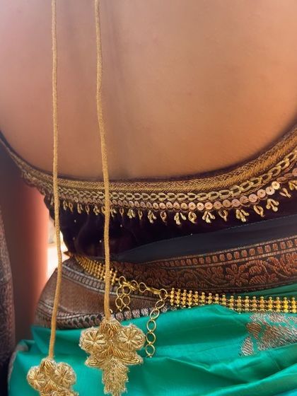 A detailed shot of the hand-embroidered tassels and the sequin work on the back of the sleeveless velvet blouse.