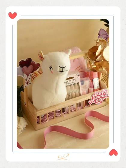 A cute and cuddly Valentine's gift featuring a white llama plushie in a wooden crate. This hamper is perfect for someone who loves adorable and unique gifts.