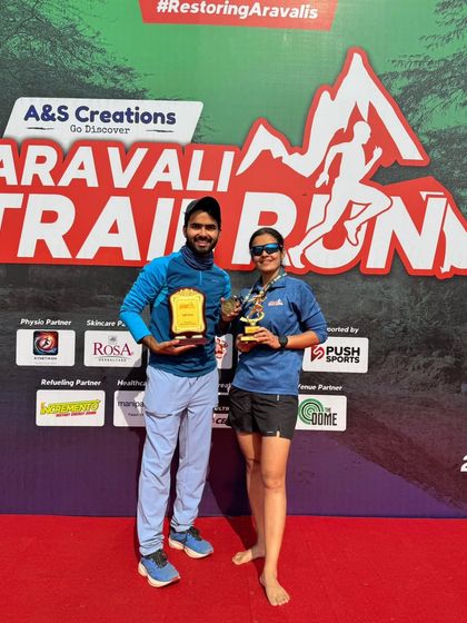 Two podium finishers with their trophies at the Aravali Trail Run. We celebrate the hard work and success of our top athletes.