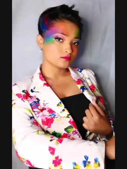A confident pose that shows off the vibrant, artistic makeup. This is a great example of how to wear bold colors for a festive event.