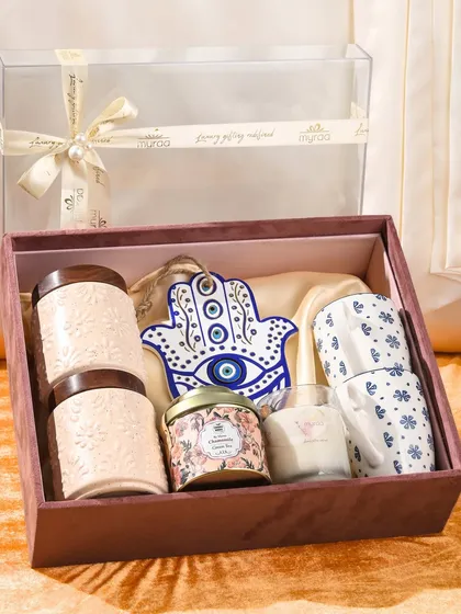For a gift that offers blessings and good vibes, I created this special Rakhi hamper. It includes ceramic jars, coffee mugs, a scented candle, and a beautiful Hamsa hand charm for protection.