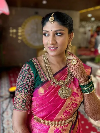 Another beautiful shot of my client, adjusting her earring. This photo captures the elegance of the overall look, from the makeup and hair to the traditional jewelry.