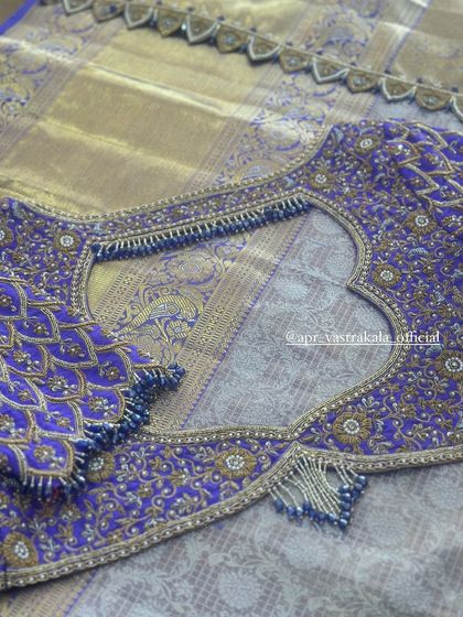 A purple blouse with intricate peacock feather embroidery.