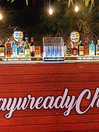 A fun and quirky bar design with a custom 'AayureadyChiru' sign and bartenders in masks, showing how we can adapt to unique party themes.