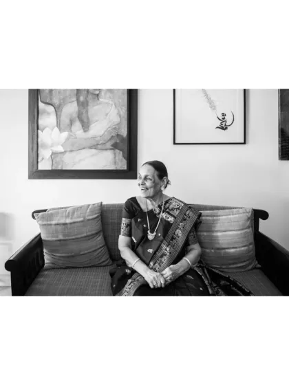 This black and white candid shot captures a moment of quiet reflection. It’s an authentic, unposed image that speaks volumes, showing her gentle smile and the peaceful atmosphere of her home.