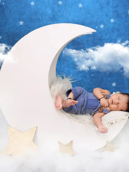 I always capture multiple angles to give you a variety of beautiful shots. This perspective shows the baby peacefully posed on the moon prop, emphasizing their tiny size against the dreamy backdrop.