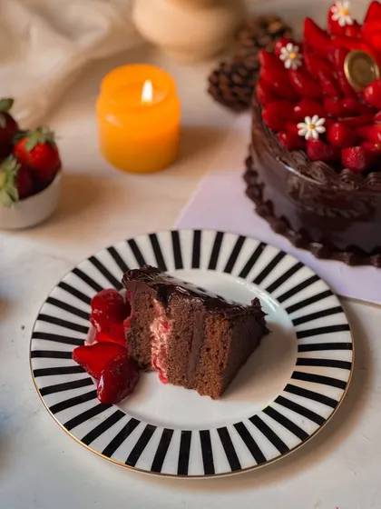 A slice of the Chocolate Strawberry Cake, showing the moist chocolate sponge and the simple, perfect pairing with fresh strawberries. It's a testament to how quality ingredients can shine.