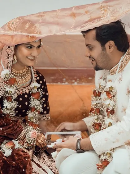 A traditional moment from a Muslim wedding, where the couple sees each other through a mirror under a veil.
