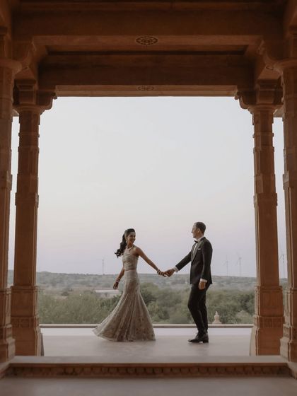 Framed by ancient pillars, the couple holds hands, ready to walk into their future together. This shot uses the stunning architecture of Suryagarh to create a sense of history and destiny.