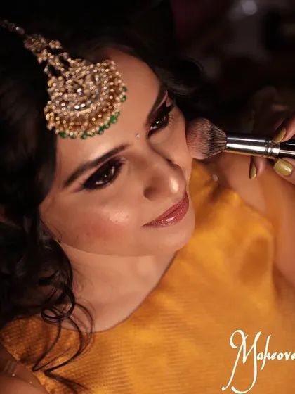 The process of creating a flawless base. Here, I am applying blush to add a natural flush of color to the cheeks for Chinmayi's mehendi look.