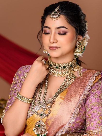A moment of quiet reflection. This shot focuses on the bride's elegant profile, the detailed jewellery, and the soft texture of her silk saree.