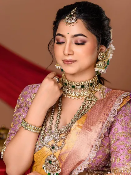 A gentle and serene portrait. The model's closed eyes and the soft lighting on her face create a peaceful mood, drawing attention to the beautiful makeup and jewelry.