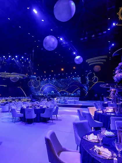 Plush velvet chairs in a soft lilac color were paired with deep blue tables, with floating planet models visible in the background, continuing the celestial journey throughout the space.