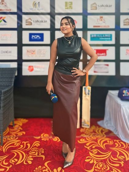 A full-length shot of my edgy black leather top and maroon skirt, perfect for a modern, stylish event like a sports league auction.