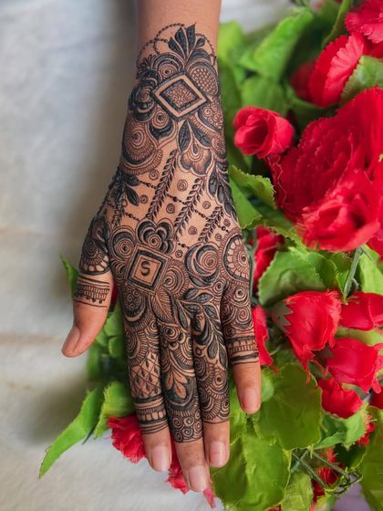 A simple yet elegant design with the initial 'S' hidden within the pattern. This is a great option for party henna or for a minimalist bride.