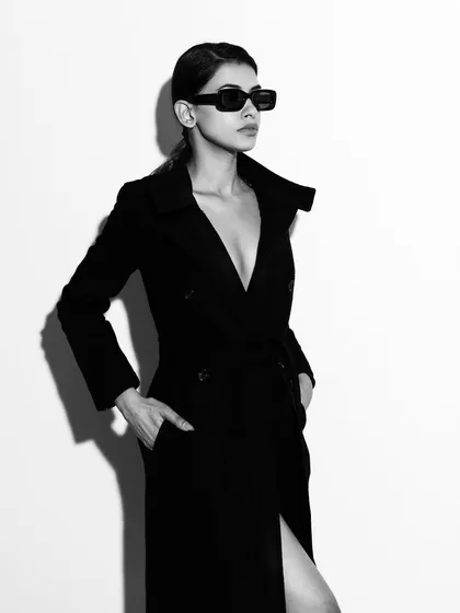 This is an example of my high-contrast studio work, creating a bold and classic fashion statement. The play of hard light and shadow defines the model's silhouette and the texture of the coat, resulting in a powerful black and white portrait.