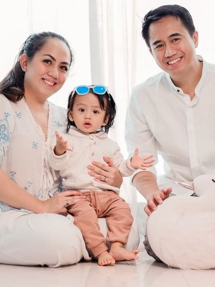 A serene family moment captured in our studio. The all-white outfits and bright, airy background create a timeless and classic family portrait.