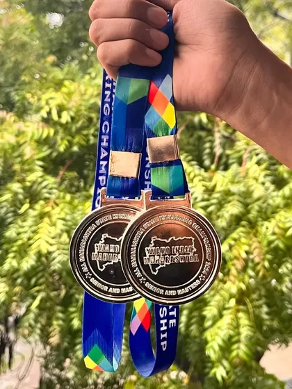 The reward for relentless effort. A close-up of the two silver medals won at the WAKO Maharashtra State Championship, a symbol of our student's hard-fought victory.