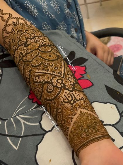A detailed shot of the forearm portion of Afrah's Pakistani-style bridal henna, with her name beautifully integrated.
