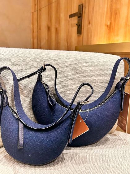 Our bestselling Selena, now in premium denim. This version offers a more casual, everyday feel while retaining the iconic crescent shape and leather details.