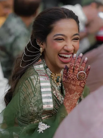 A beautiful candid moment, with the bride's half-updo and pearl accessory looking stunning.